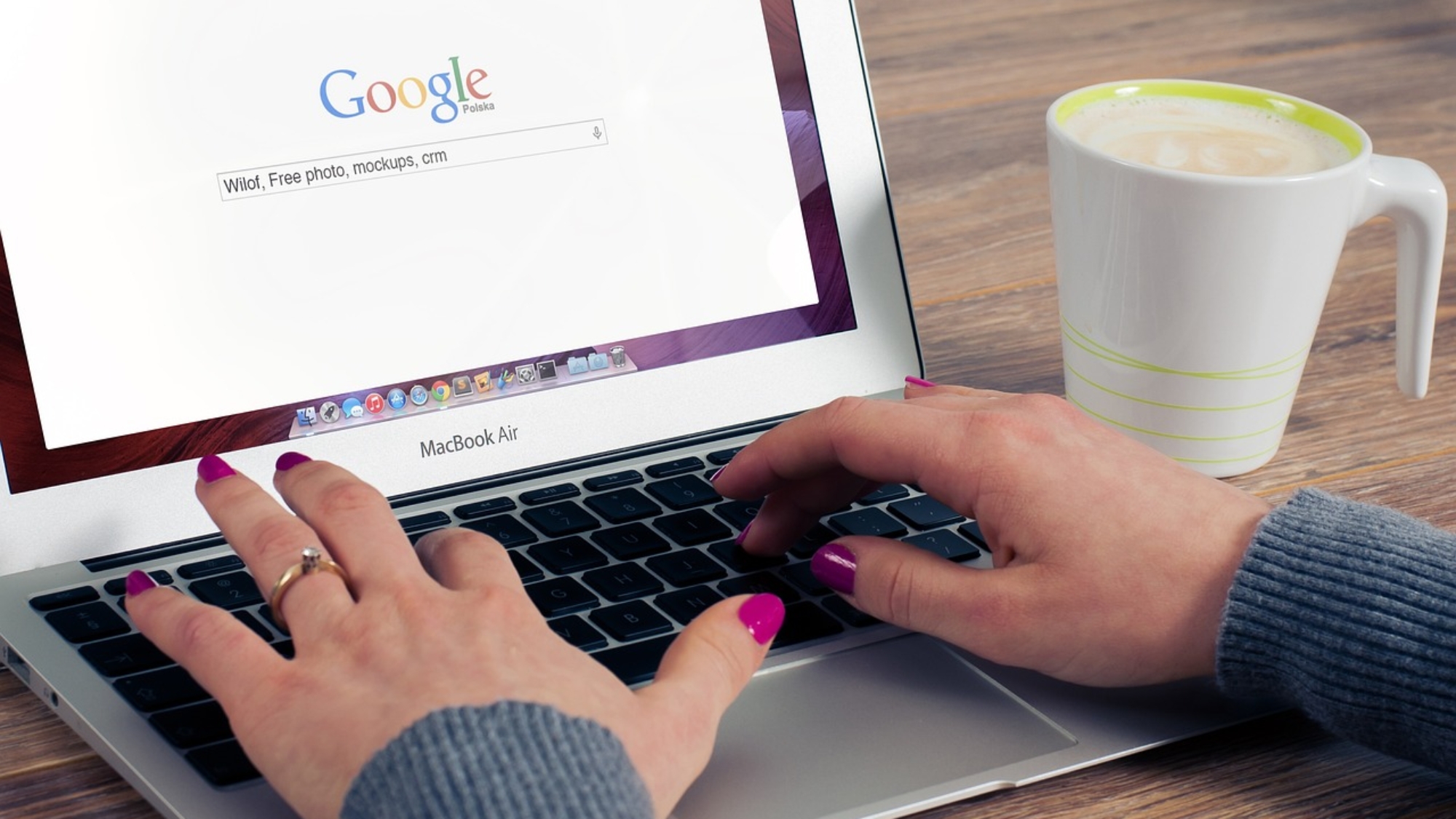 Dłonie kobiety wpisujące w wyszukiwarkę Google hasło
